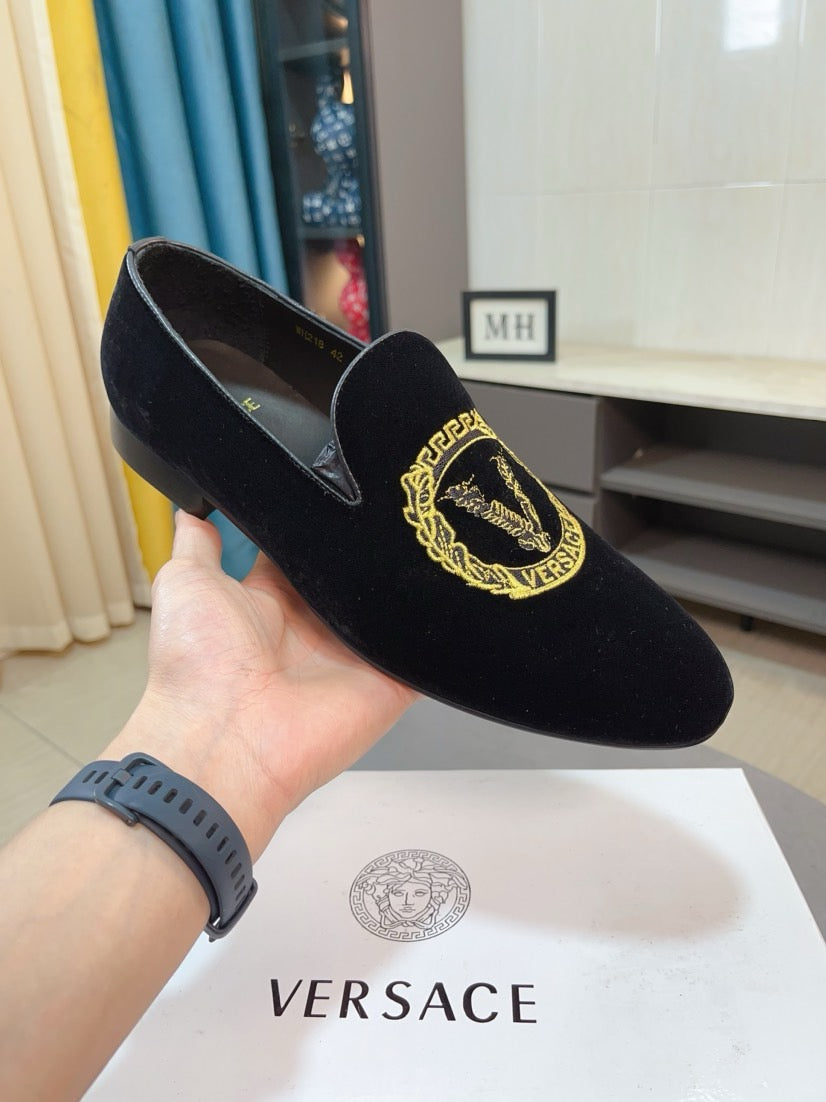 Black velvet loafer with gold embroidered emblem, shown from top and sole