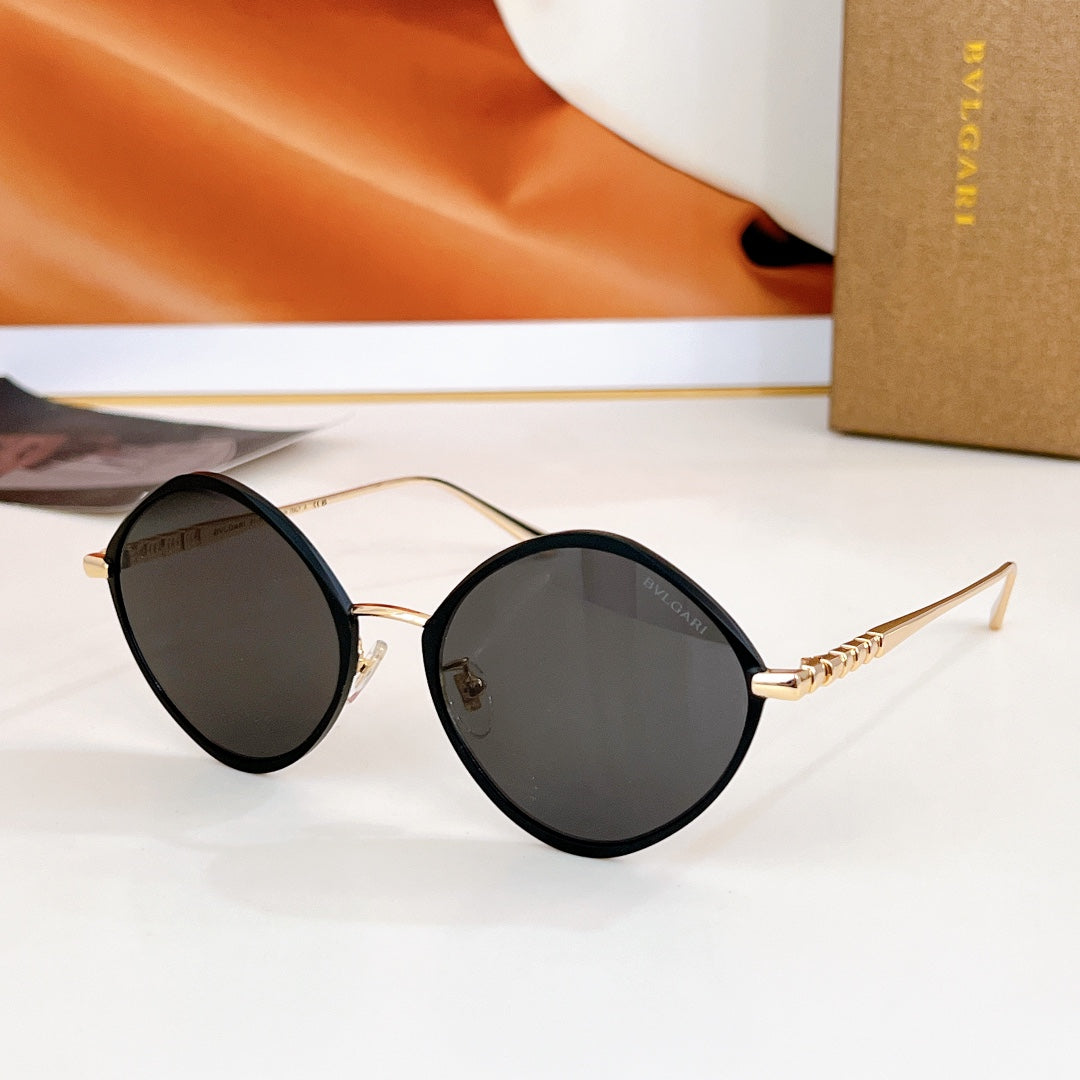 Round sunglasses with black frame and dark lenses, gold-tone temples.