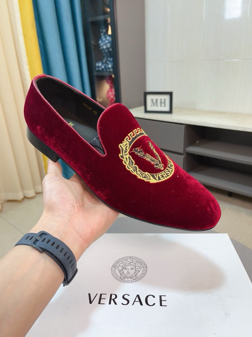 Burgundy velvet slip-on loafer with gold crest embroidery on the front