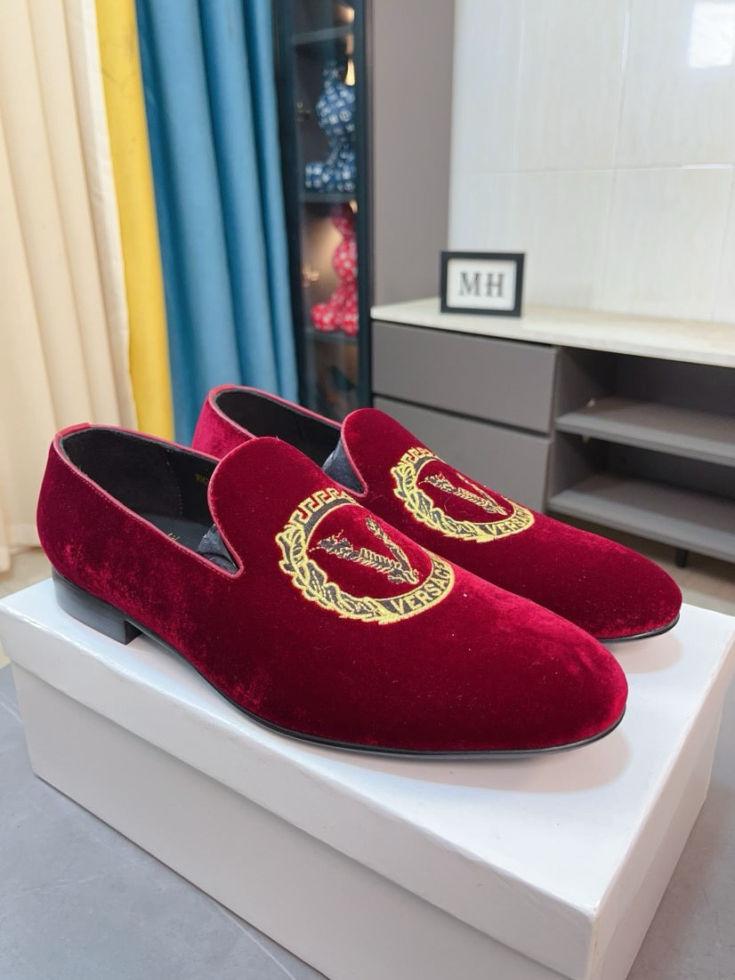 Burgundy velvet loafers with gold crest embroidery and low heel