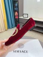 Burgundy velvet loafer with gold crest embroidery, shown in a side view