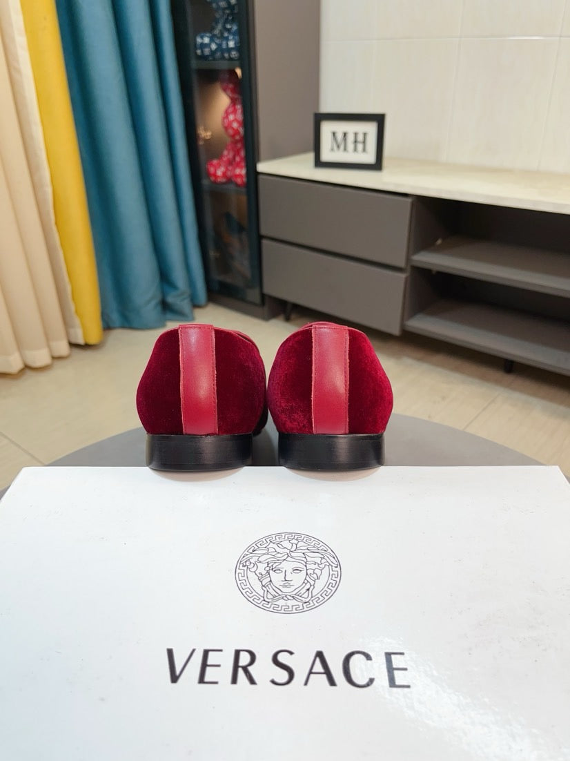 Burgundy velvet loafers with low stacked heels, shown from the back