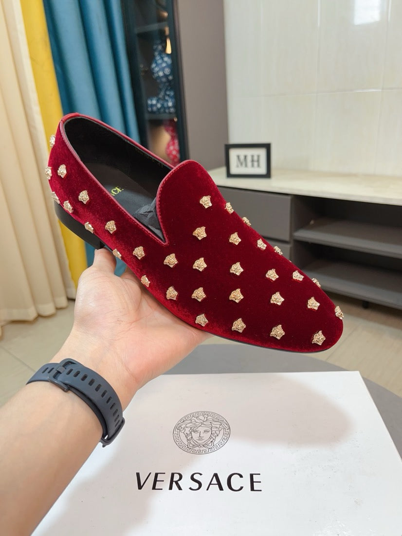 Hand-held Versace red velvet loafers with gold stud details and rounded toe.