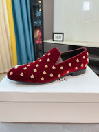 Red velvet slip-on loafers with gold stud pattern, low profile outsole.