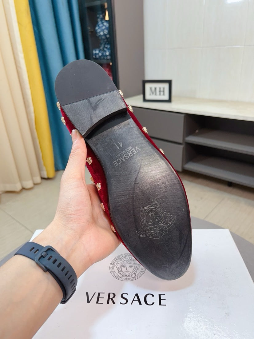 Back view of red velvet Versace loafers showing heel and dark interior lining.