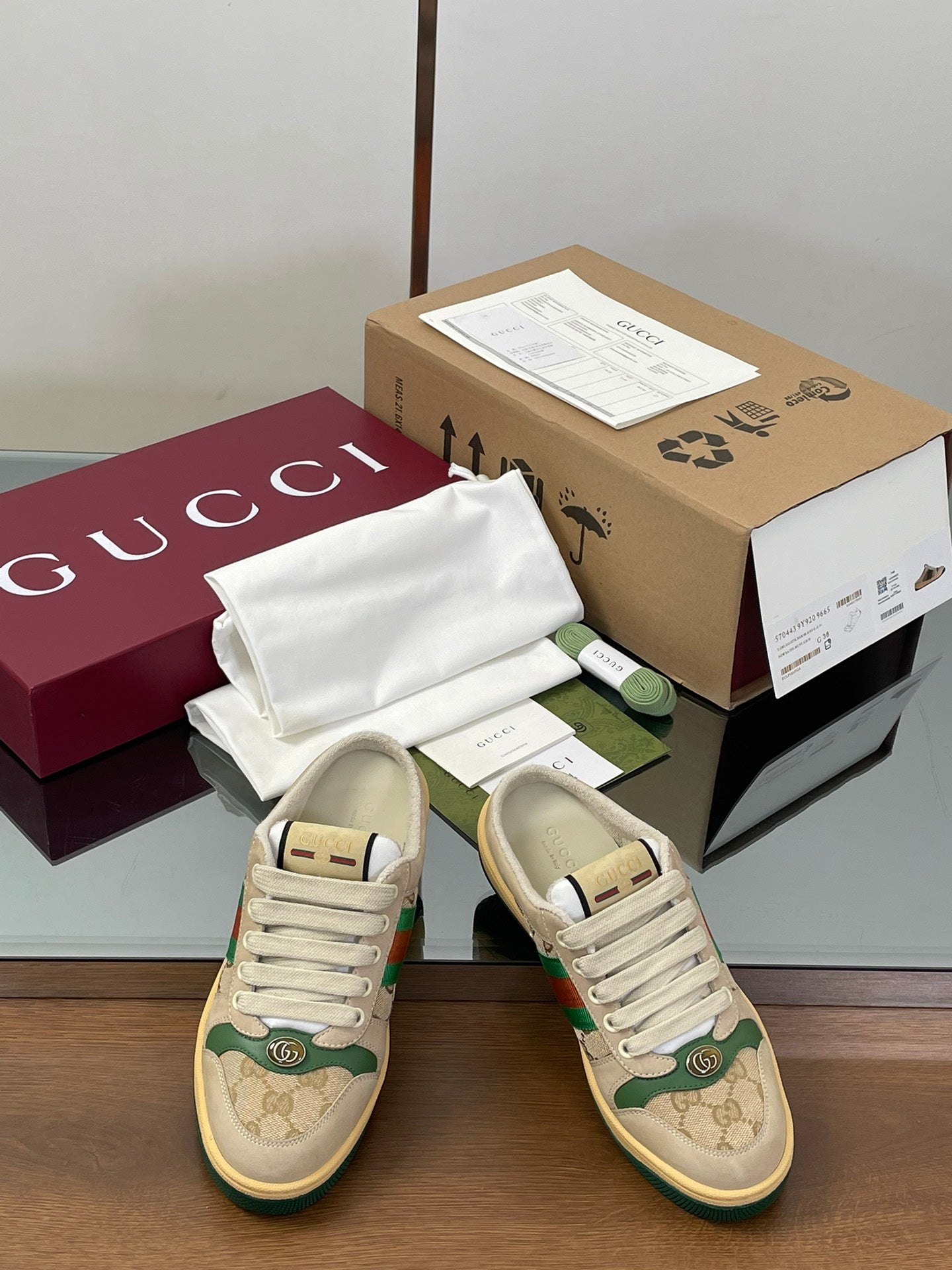 Pair of Gucci low-top sneakers, beige with green web stripe and lace-up closure.
