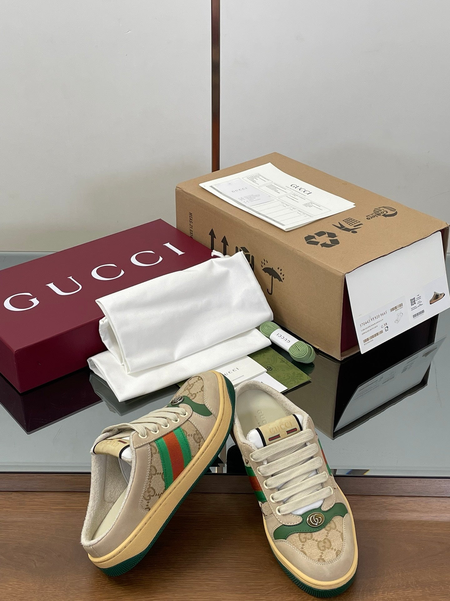 Gucci lace-up sneakers, beige canvas with green web stripe detail on the sides.