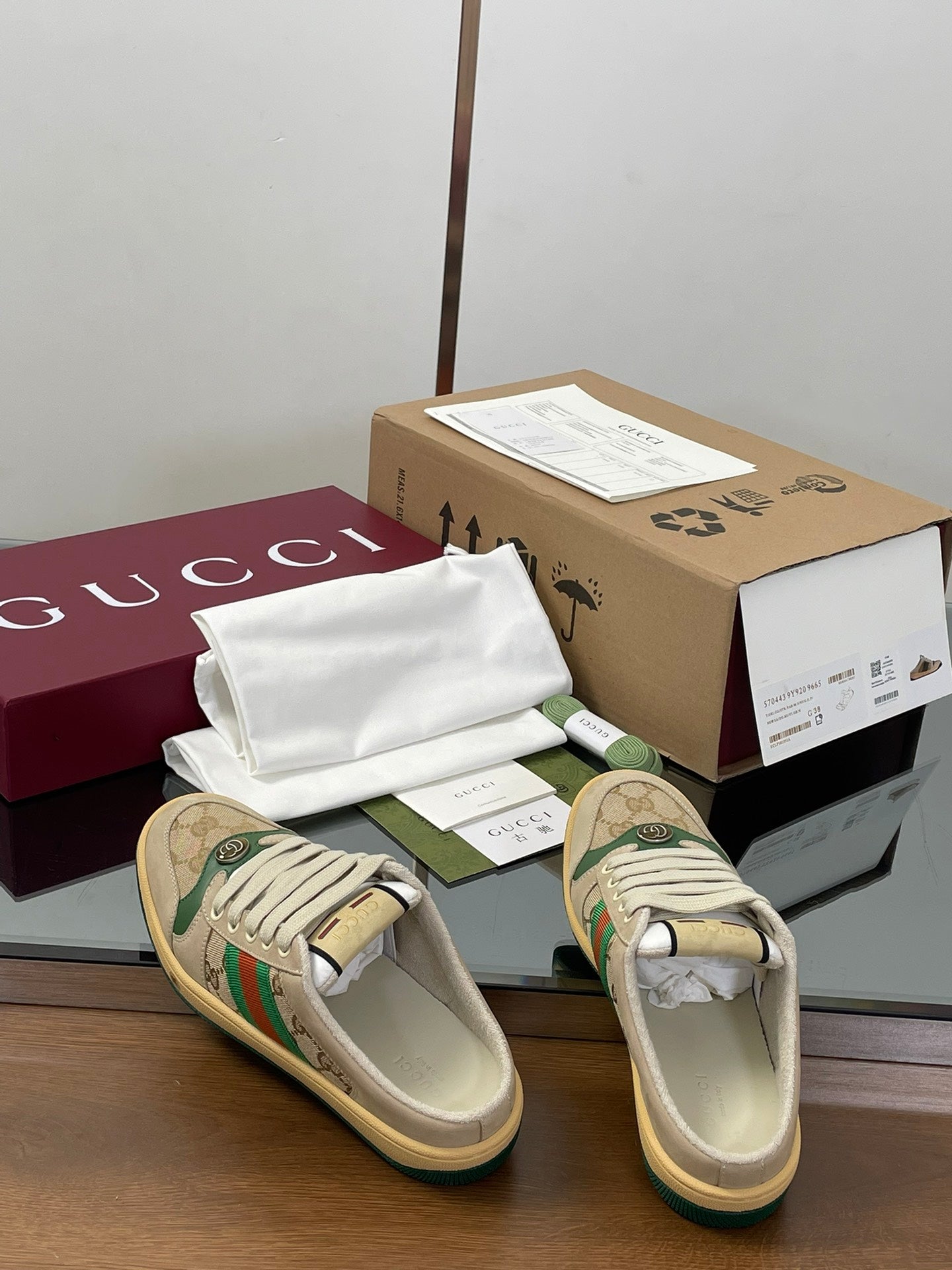 Gucci sneakers in beige with green accents, lace-up front view with rubber sole.