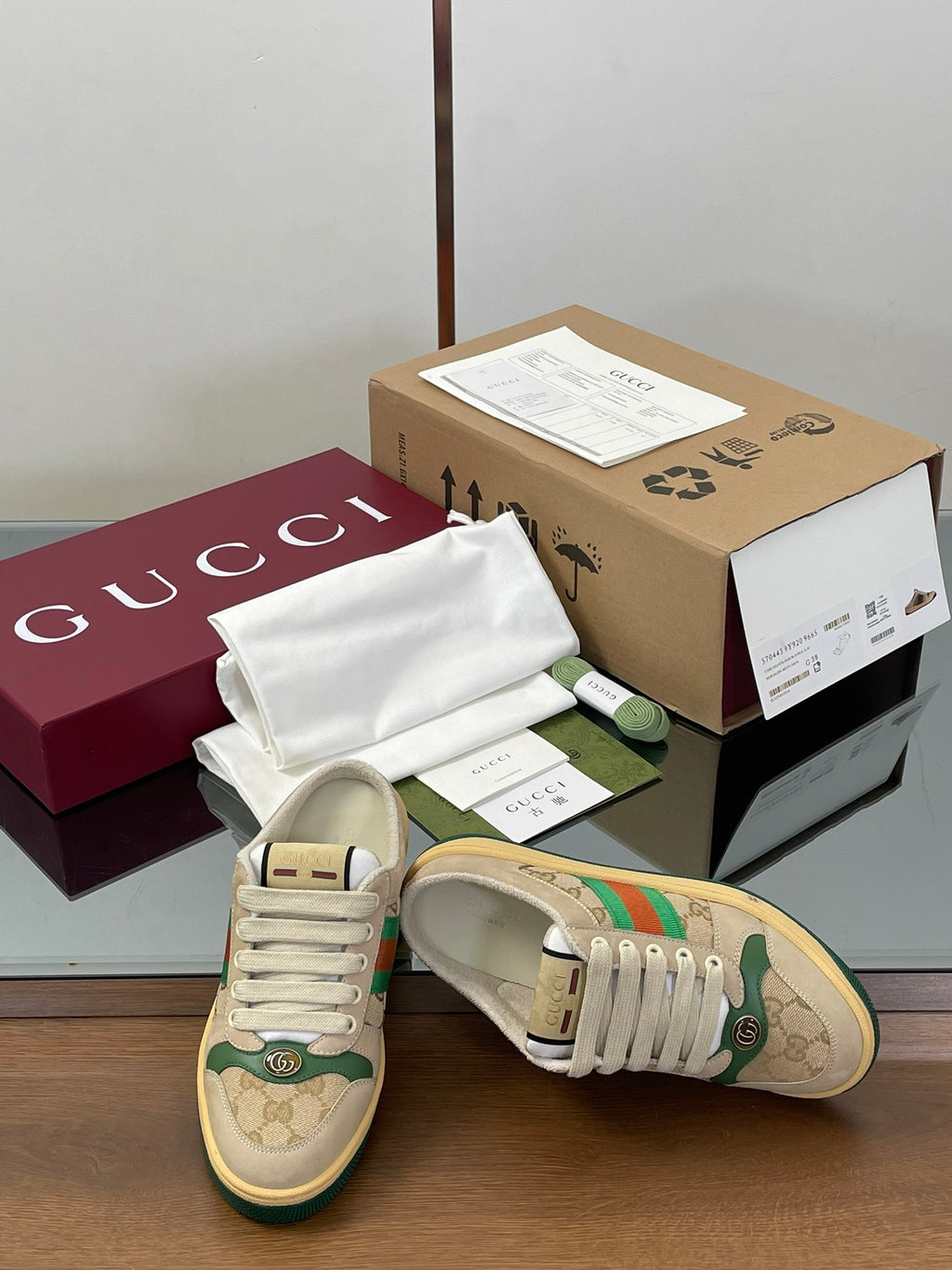 Low-top sneakers with beige uppers, green graphic stripe, white laces, toe view