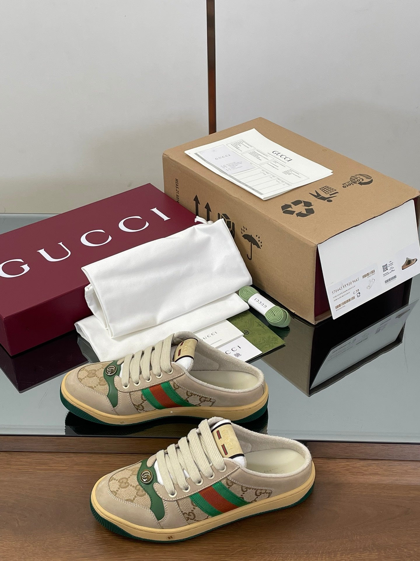 Gucci low-top sneakers, beige uppers with green web stripe and white laces.