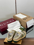 Gucci lace-up sneakers from behind, beige with green web stripe and rubber sole.