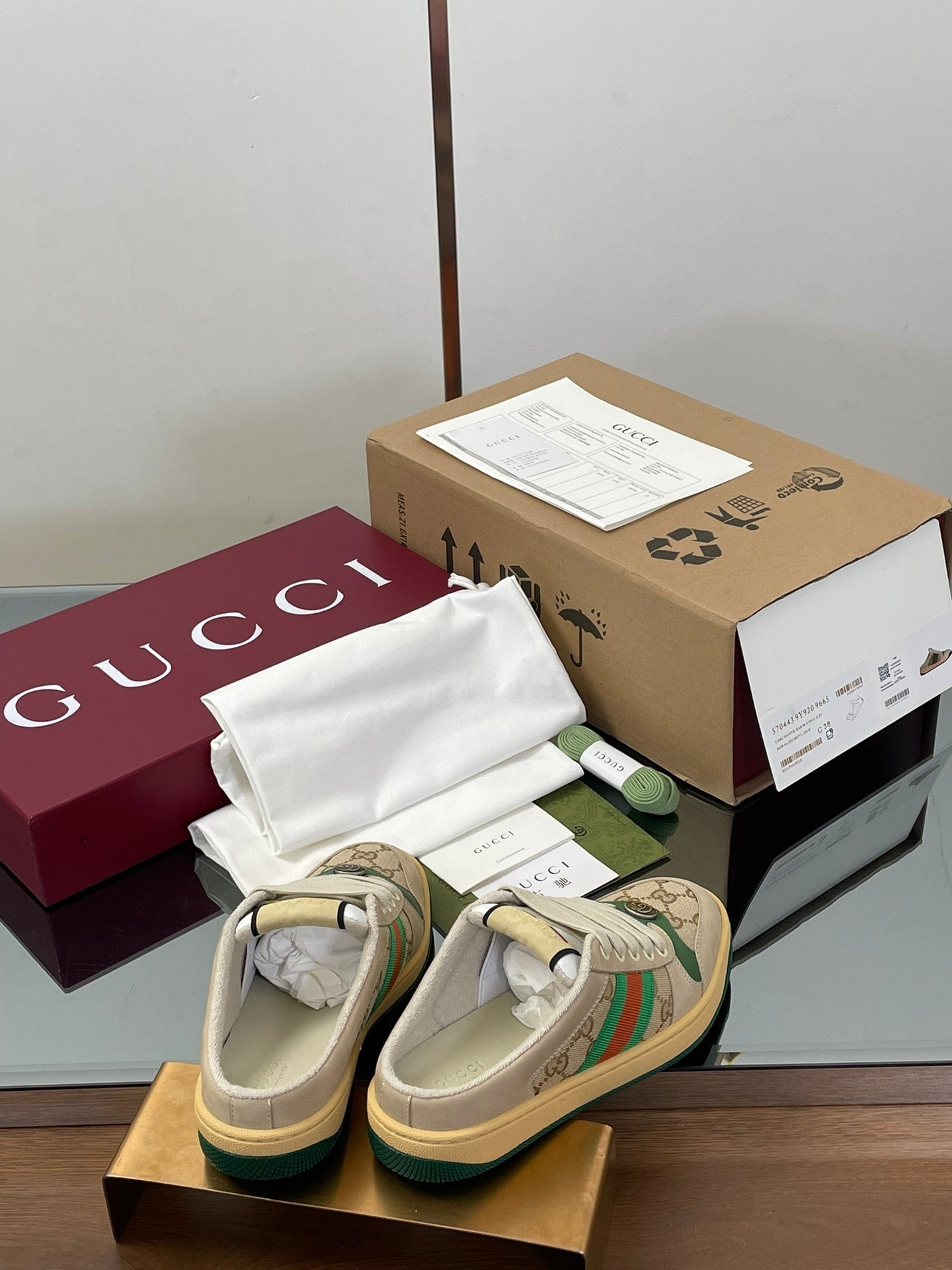 Gucci lace-up sneakers from behind, beige with green web stripe and rubber sole.