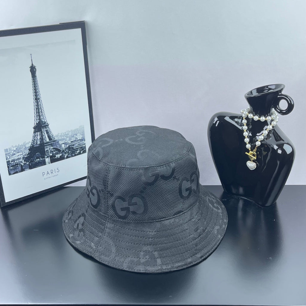 Gucci bucket hat in dark gray with repeating GG logo pattern and curved stitched edge