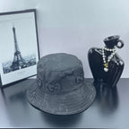 Gucci bucket hat in dark gray with repeating GG logo pattern and curved stitched edge