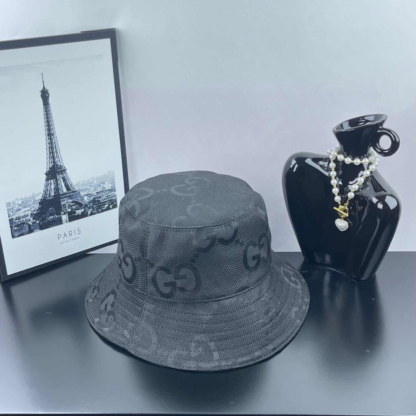 Gucci bucket hat in dark gray with repeating GG logo pattern and curved stitched edge