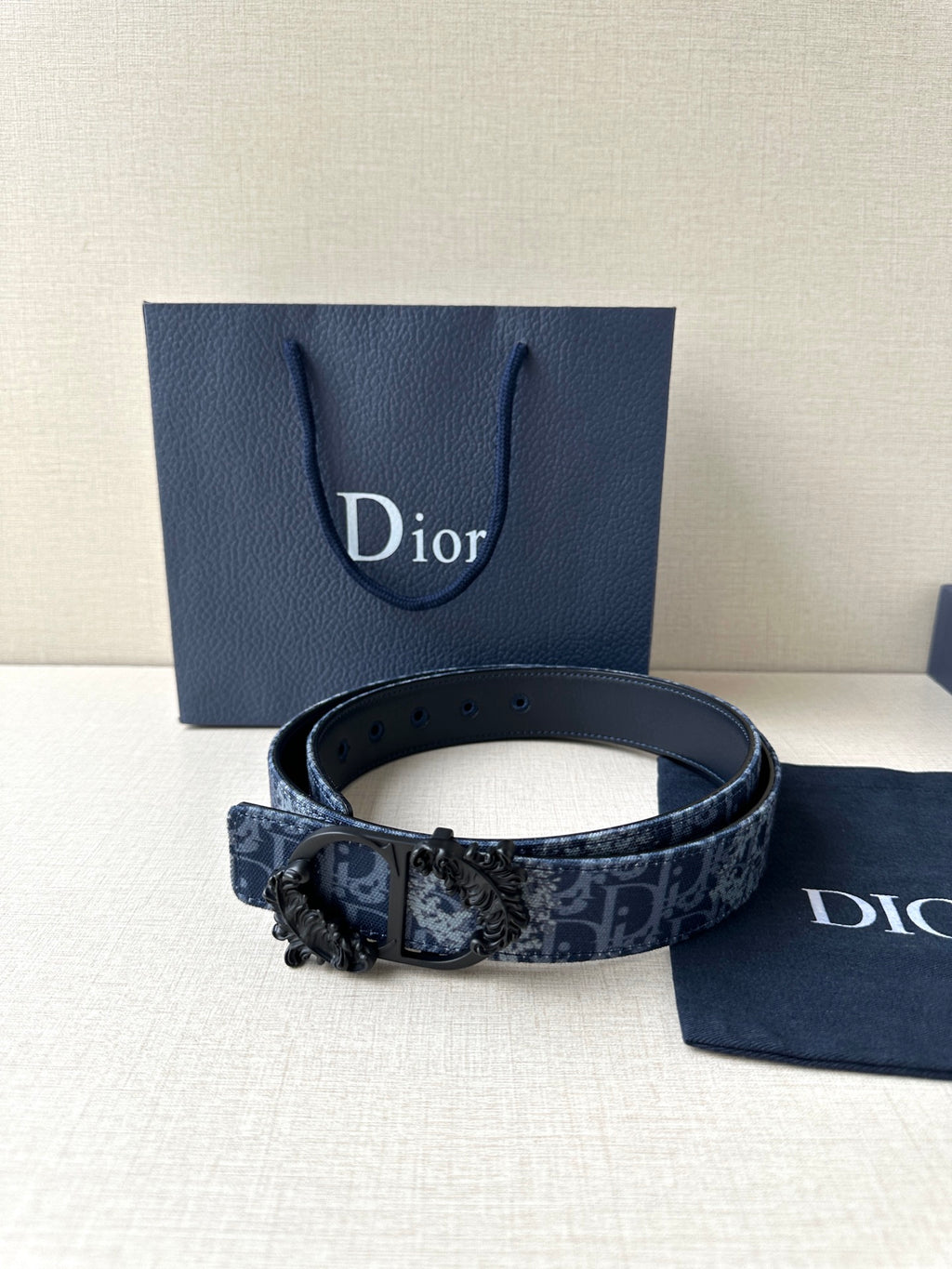 Navy Dior belt with blue monogram canvas and ornate black buckle clasp.