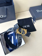 Dior belt laid flat with dark blue monogram strap and gold buckle