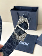 Dior belt buckle close-up: dark blue monogram strap with silver-toned ornate frame