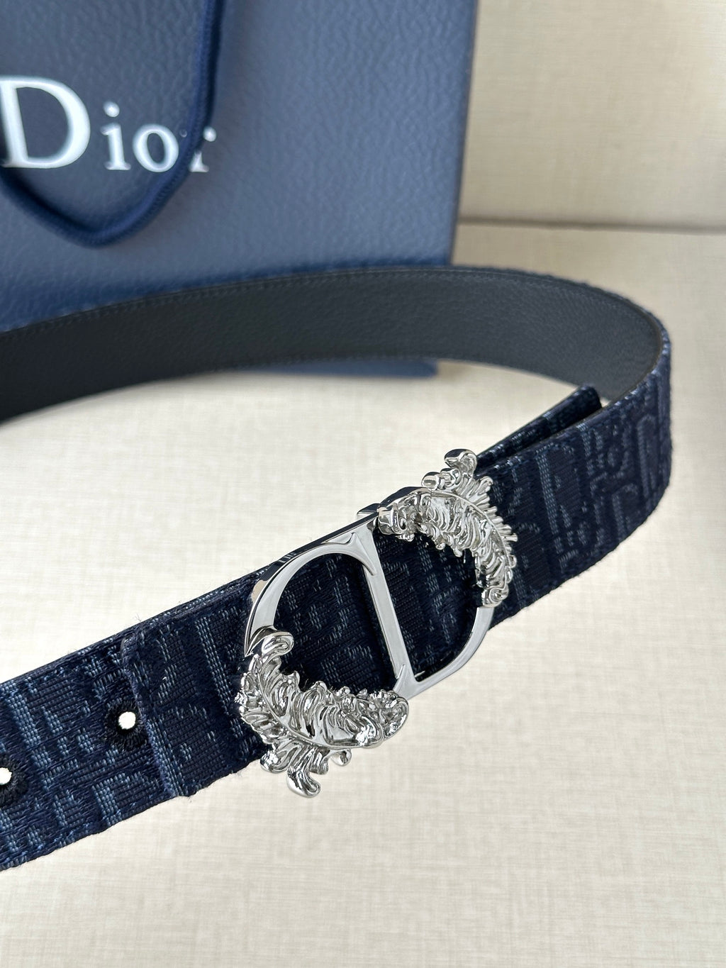 Navy Dior belt detail with black center buckle and silver decorative frame