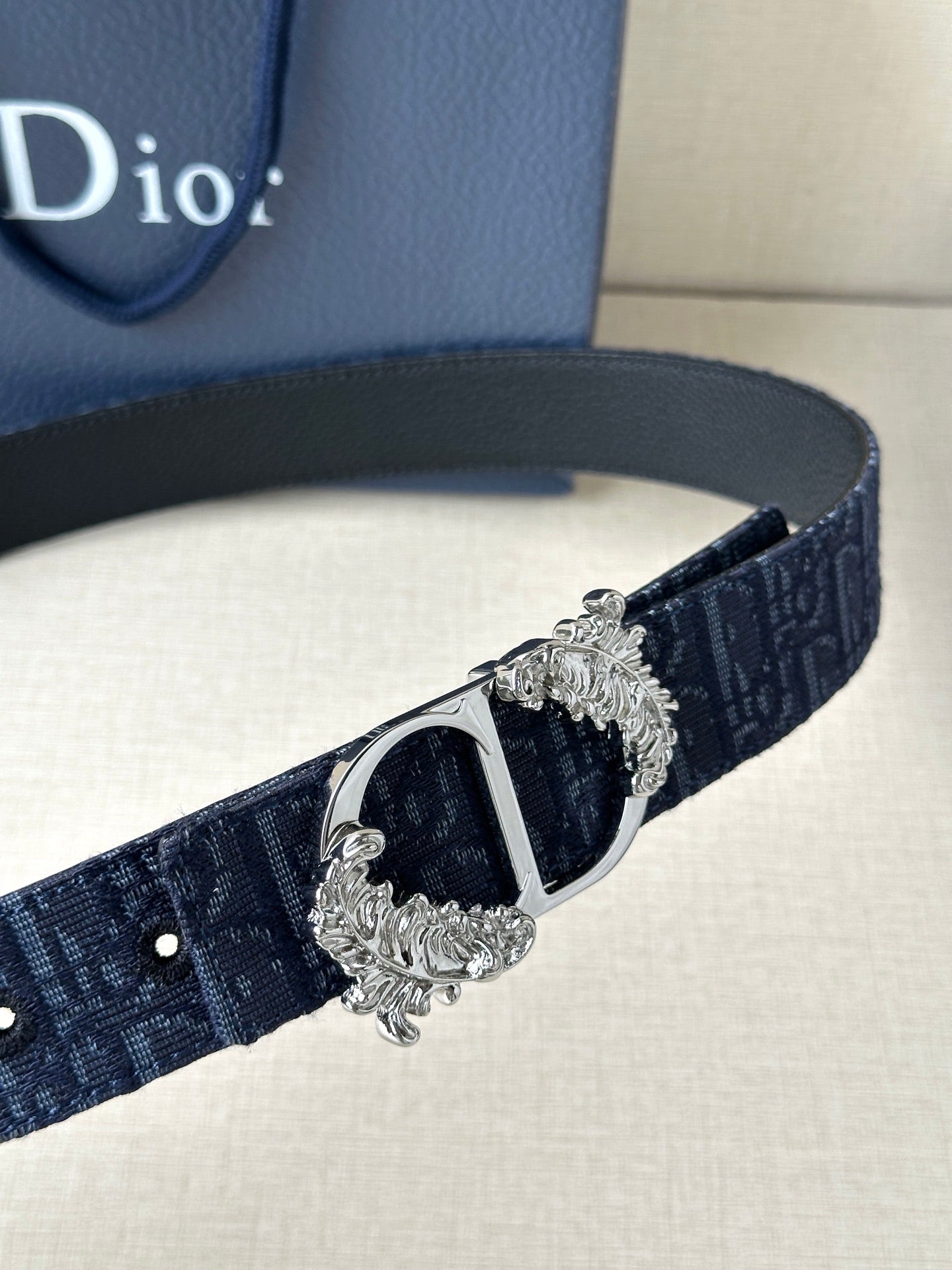 Navy Dior belt detail with black center buckle and silver decorative frame