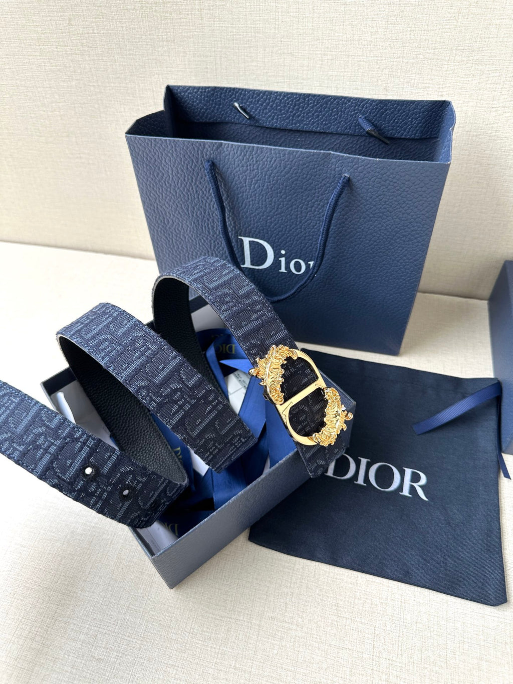 Dark blue Dior belt with gold-tone oval buckle and monogram strap in box