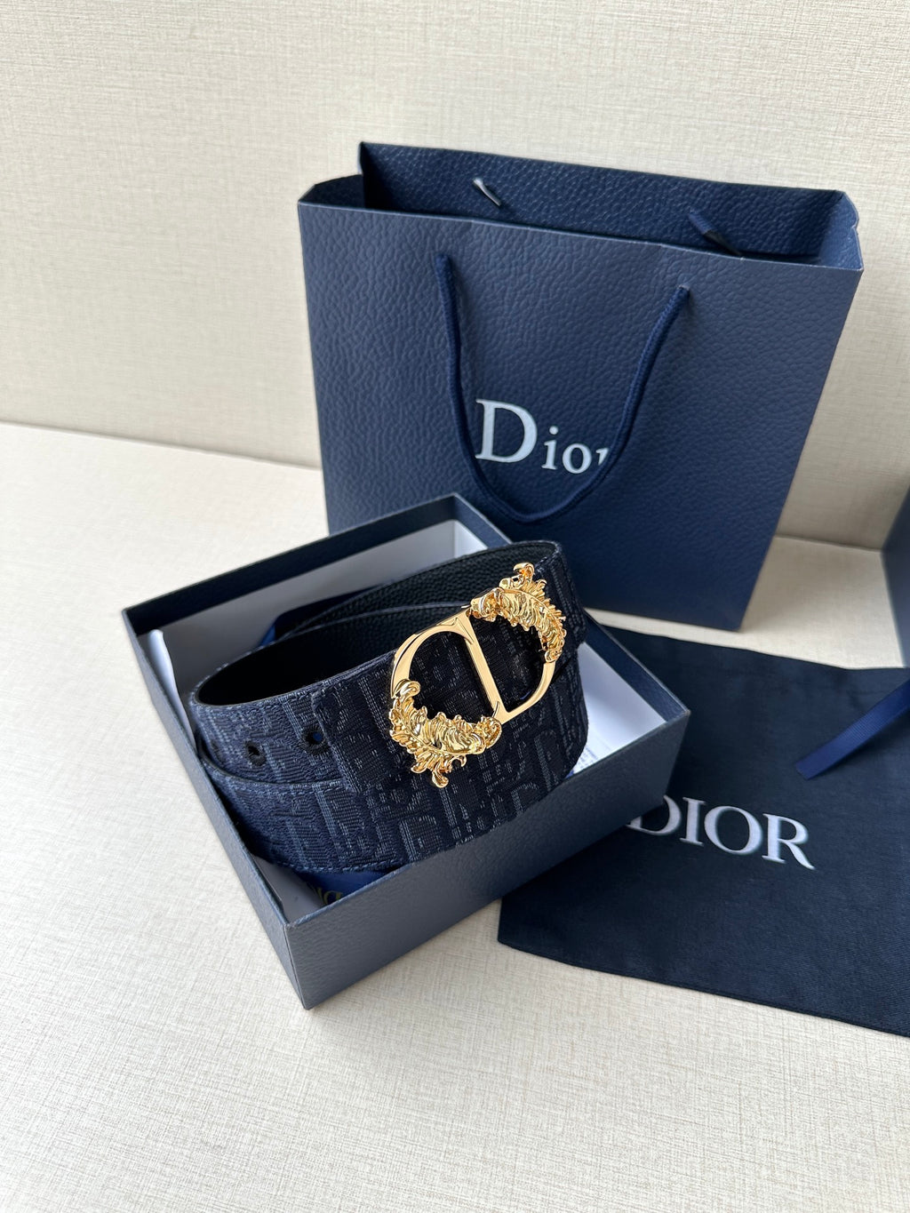 Dark blue Dior belt with gold-tone oval buckle on box insert