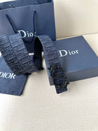 Dior belt close view: dark blue monogram-style strap with black sculpted buckle