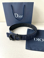 Dior belt with dark blue strap, black buckle centerpiece, and punched adjustment holes