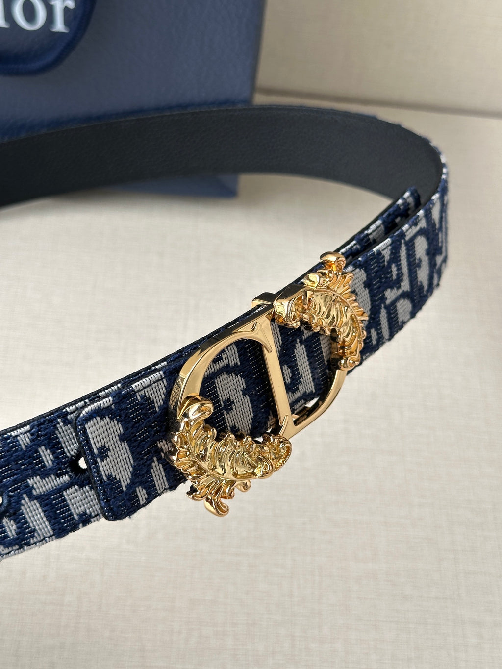Navy and light blue logo belt with gold-tone double buckle hardware detail