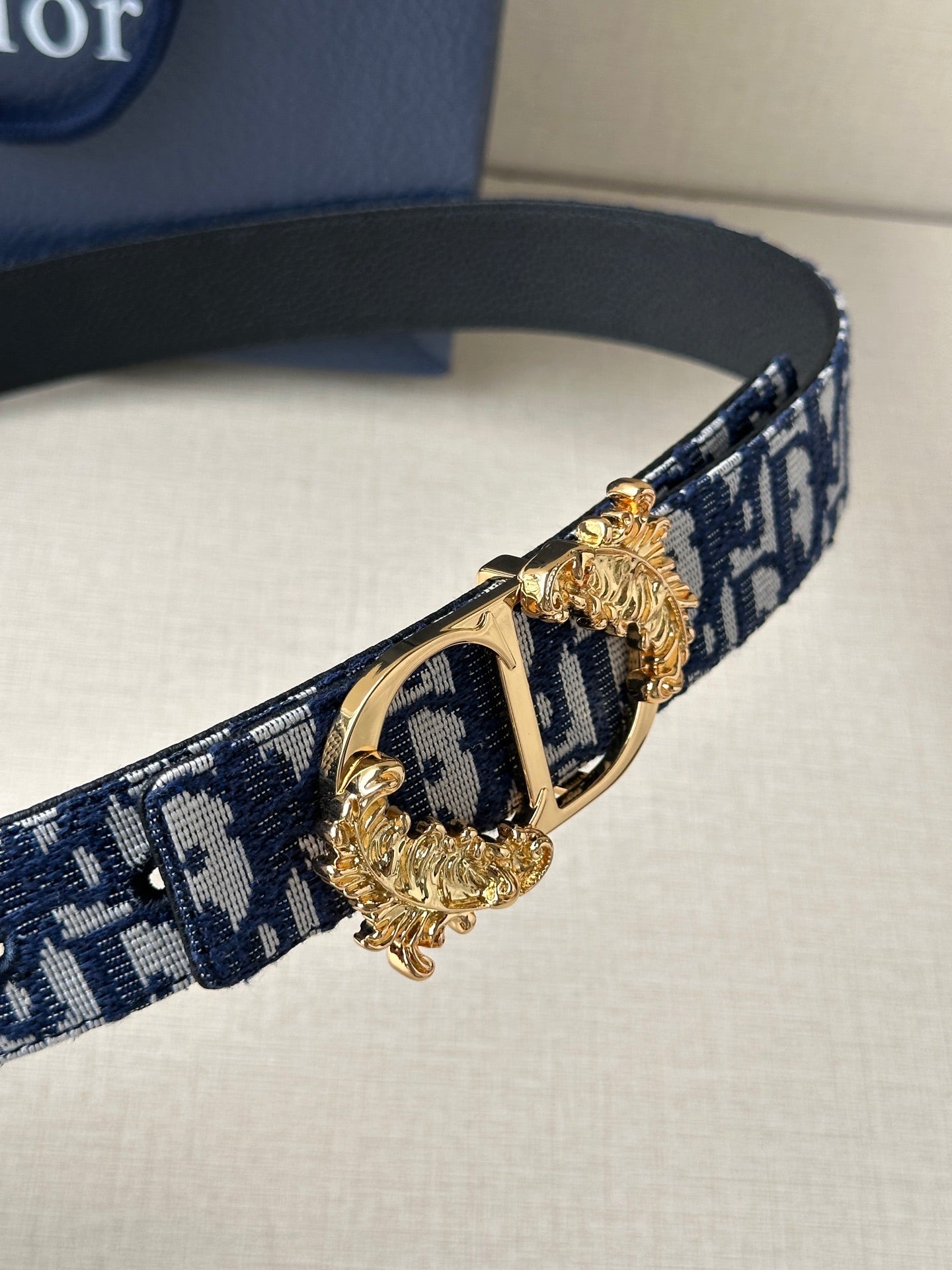 Navy and light blue logo belt with gold-tone double buckle hardware detail