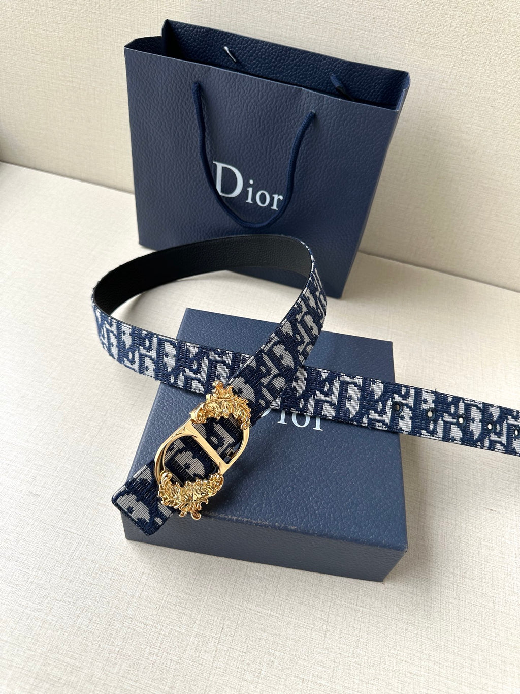 Dior belt with navy logo canvas strap and ornate gold-tone buckle detail