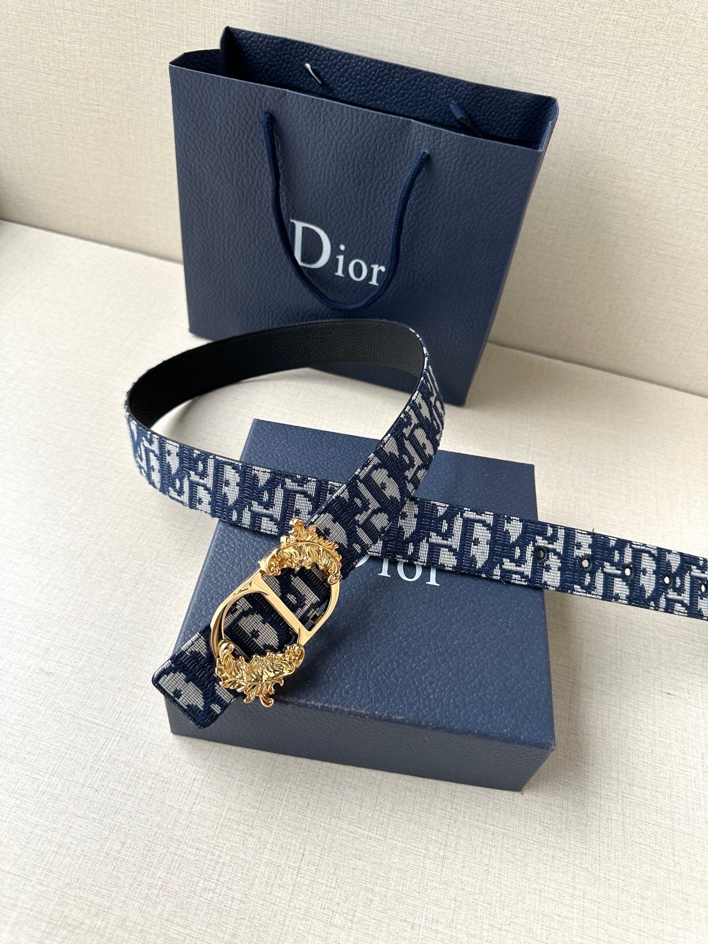 Dior belt with navy logo canvas strap and ornate gold-tone buckle detail