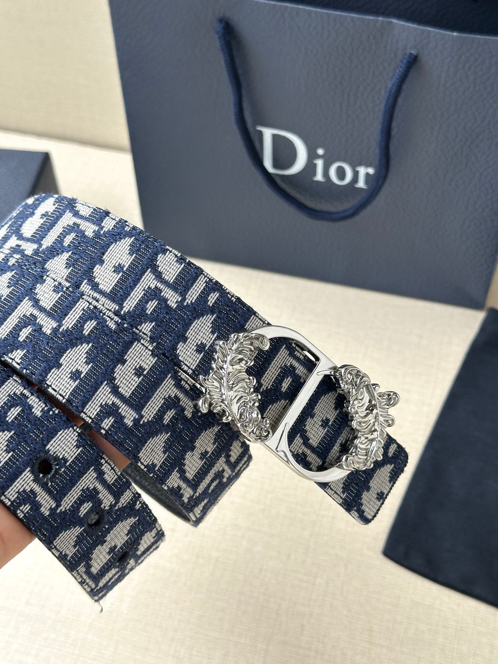 Navy and light blue logo belt with silver-toned buckle and decorative crest
