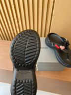 Black sandal outsoles with tread pattern, rear views of thong sandals
