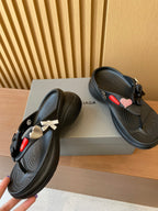 Black sandals with ribbon bow charm and heart detail, sculpted thong sole