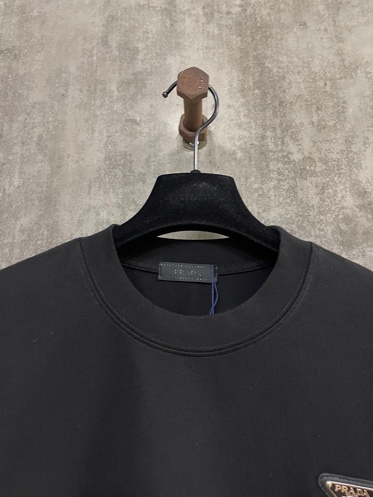 Black T-shirt neckline with inner brand tag and Prada insignia