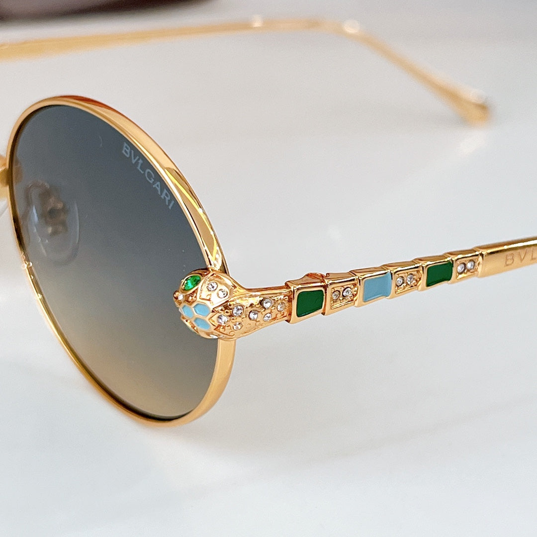 Close-up of gold round sunglasses with dark lenses and jeweled temple inlays