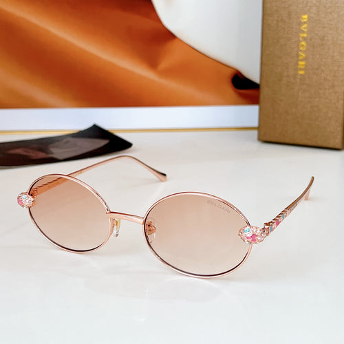 Rose gold round sunglasses with pink lenses and jeweled detail on the temple