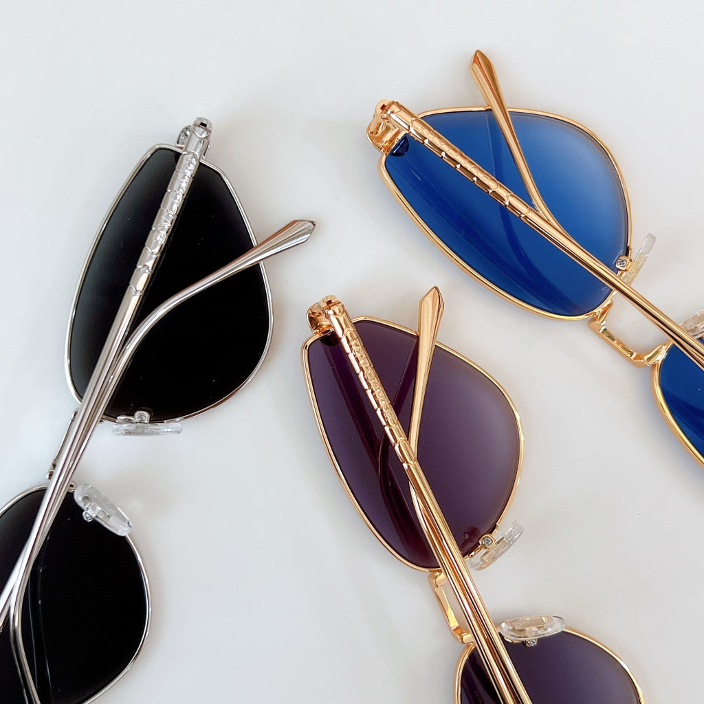 Cat-eye sunglasses with mixed silver and gold frames and blue or purple gradient lenses