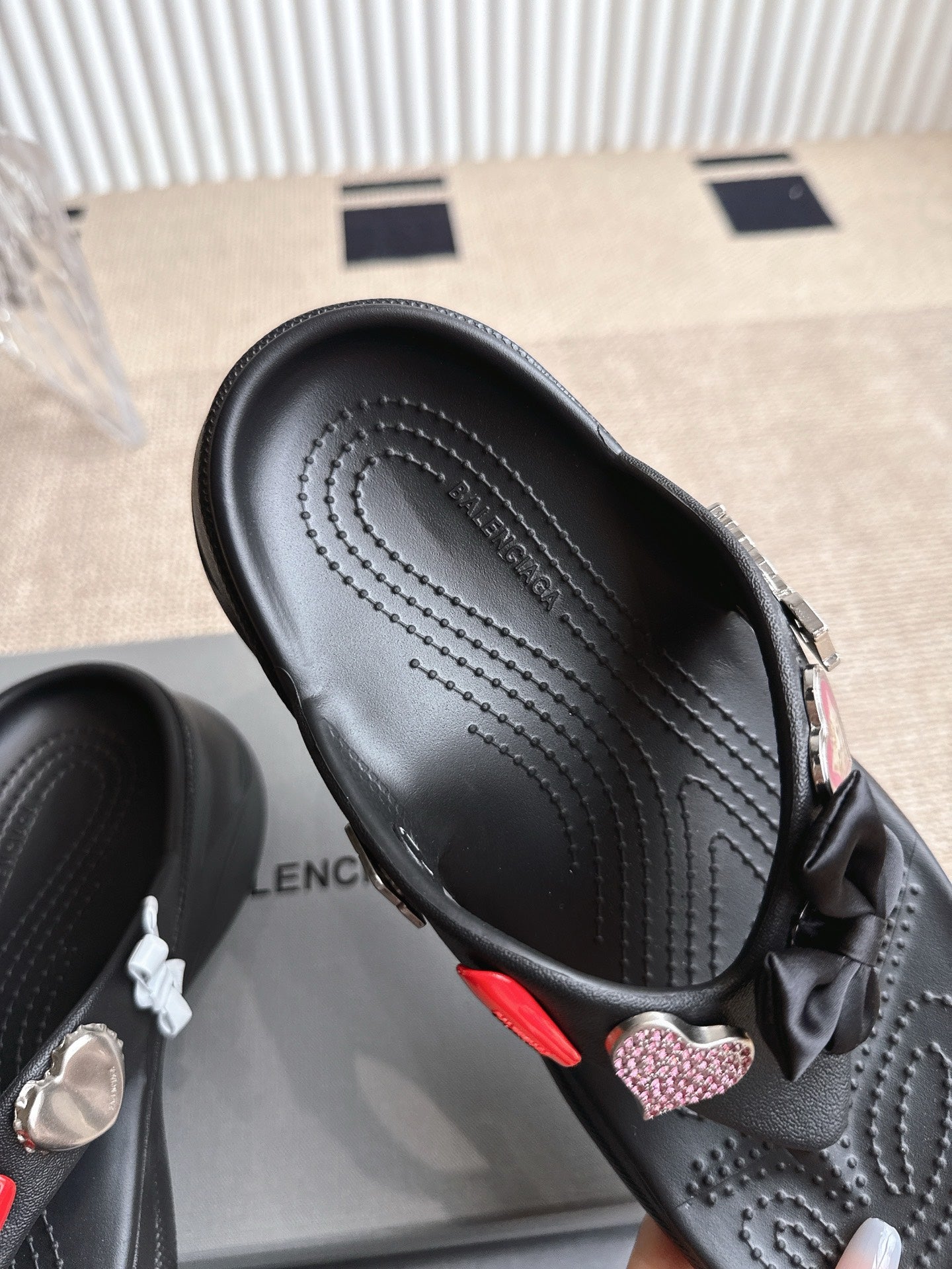 Balenciaga black sandal with textured footbed and bow strap detail, close-up angle