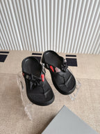 Balenciaga black sandals with bow straps and textured footbed, angled close view