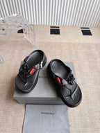 Balenciaga black sandals with bow detail and textured footbed, showing side profile