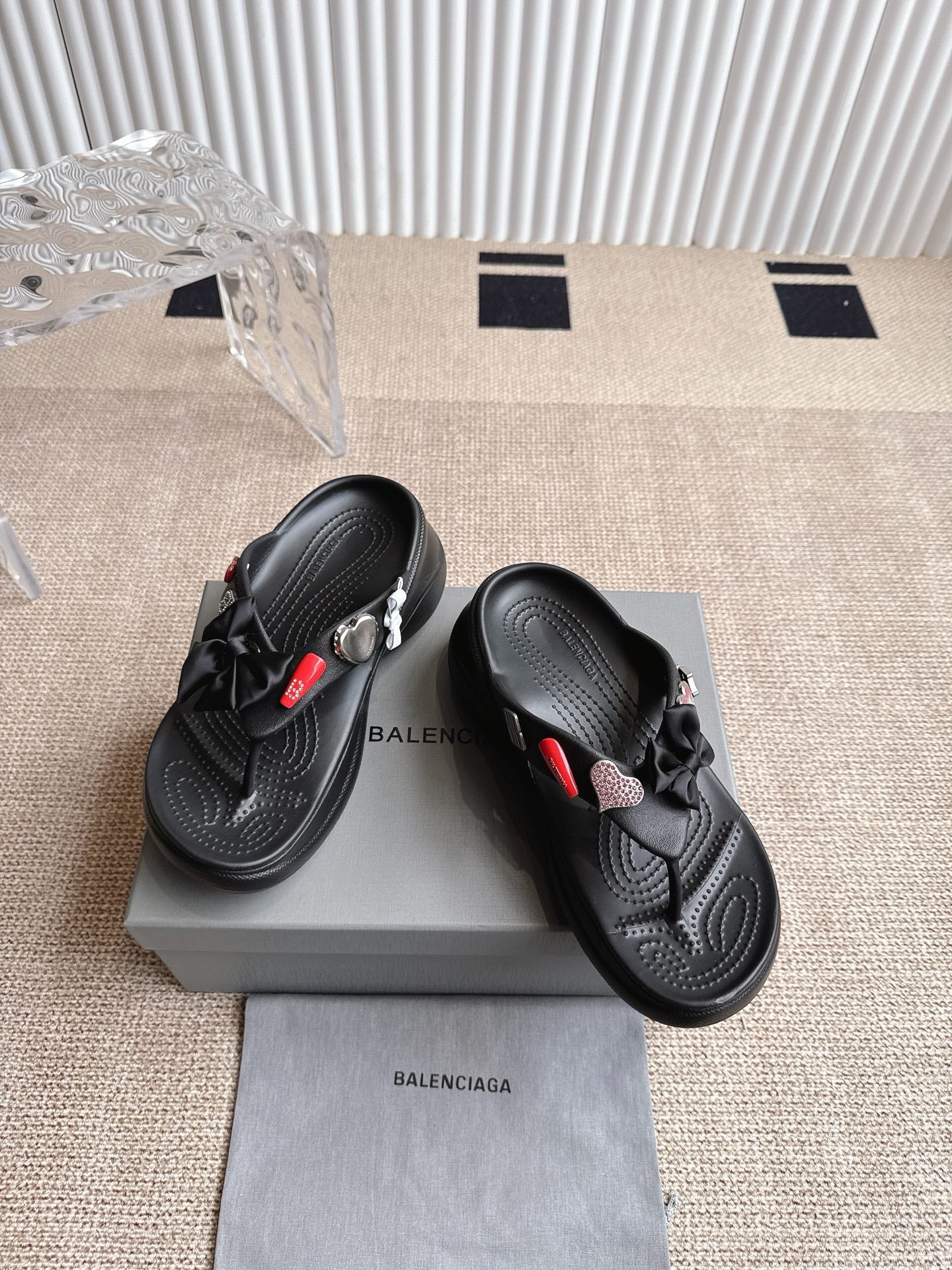 Balenciaga black sandals with bow detail and textured footbed, showing side profile