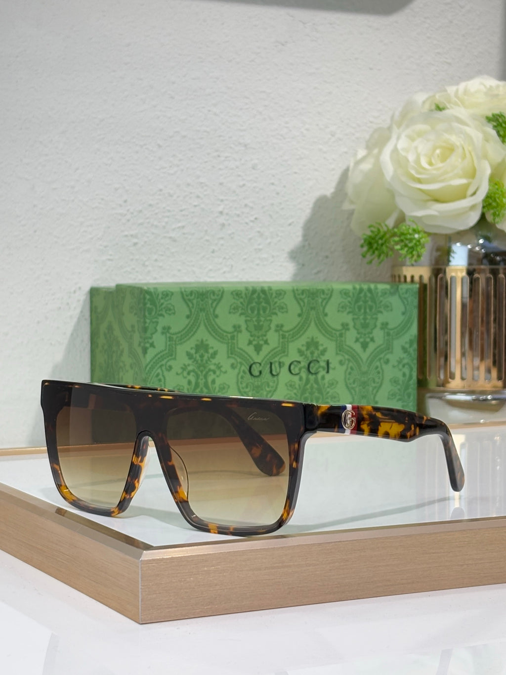 Gucci sunglasses with tortoise-pattern frames and dark amber lenses, gold emblem