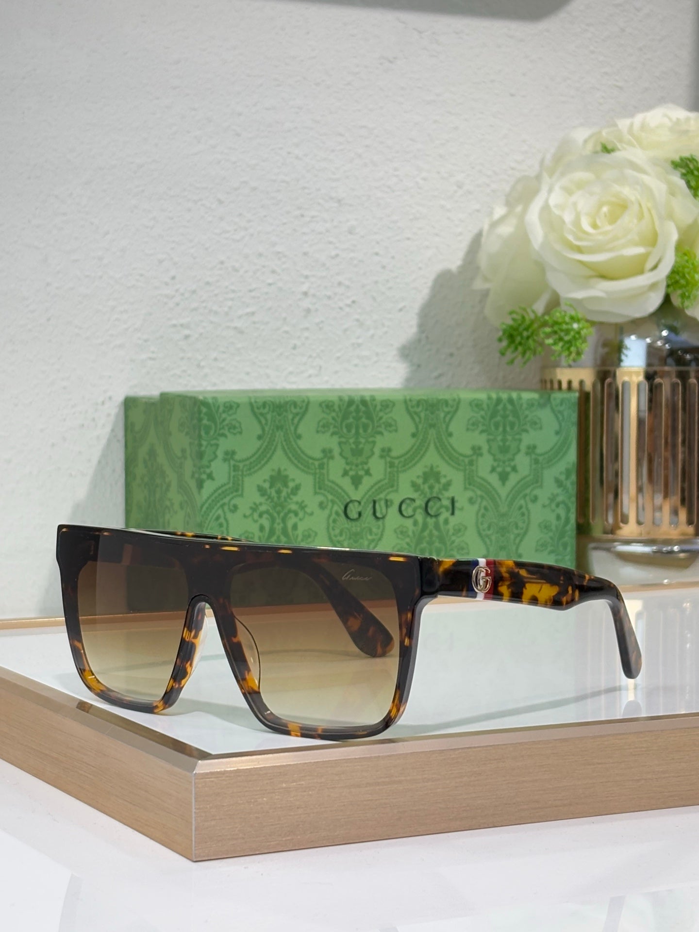 Gucci sunglasses with tortoise-pattern frames and dark amber lenses, gold emblem