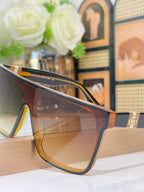 Gucci sunglasses close-up with tortoise frames and amber lenses, gold temple hardware
