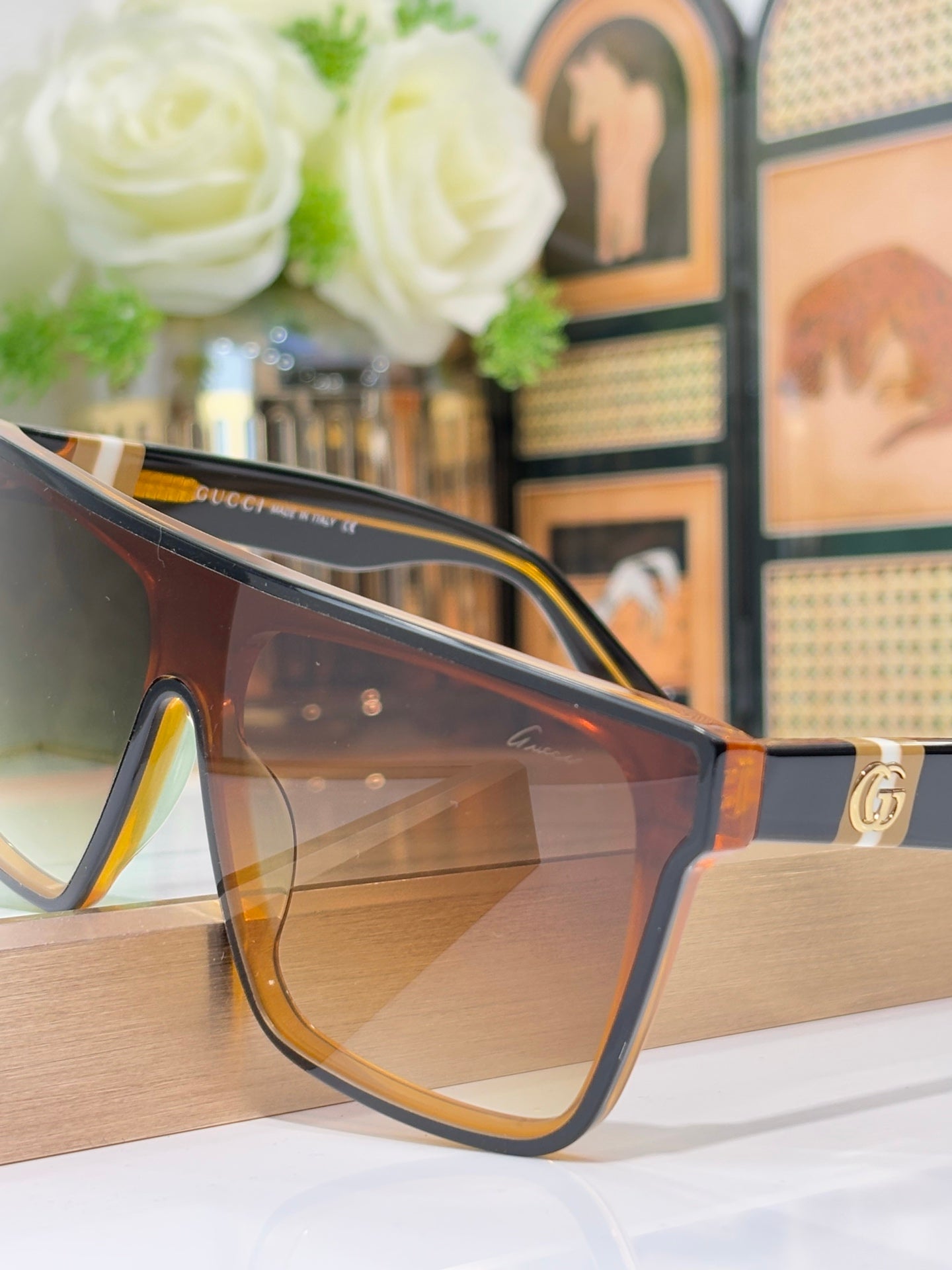 Gucci sunglasses close-up with tortoise frames and amber lenses, gold temple hardware