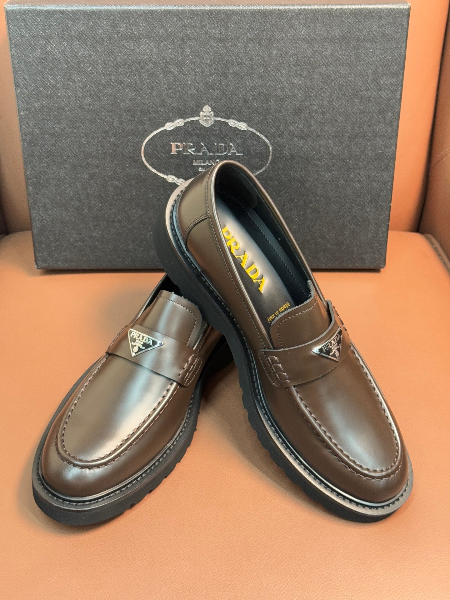 Prada unisex loafers with dark metallic brown leather and green Prada insole text