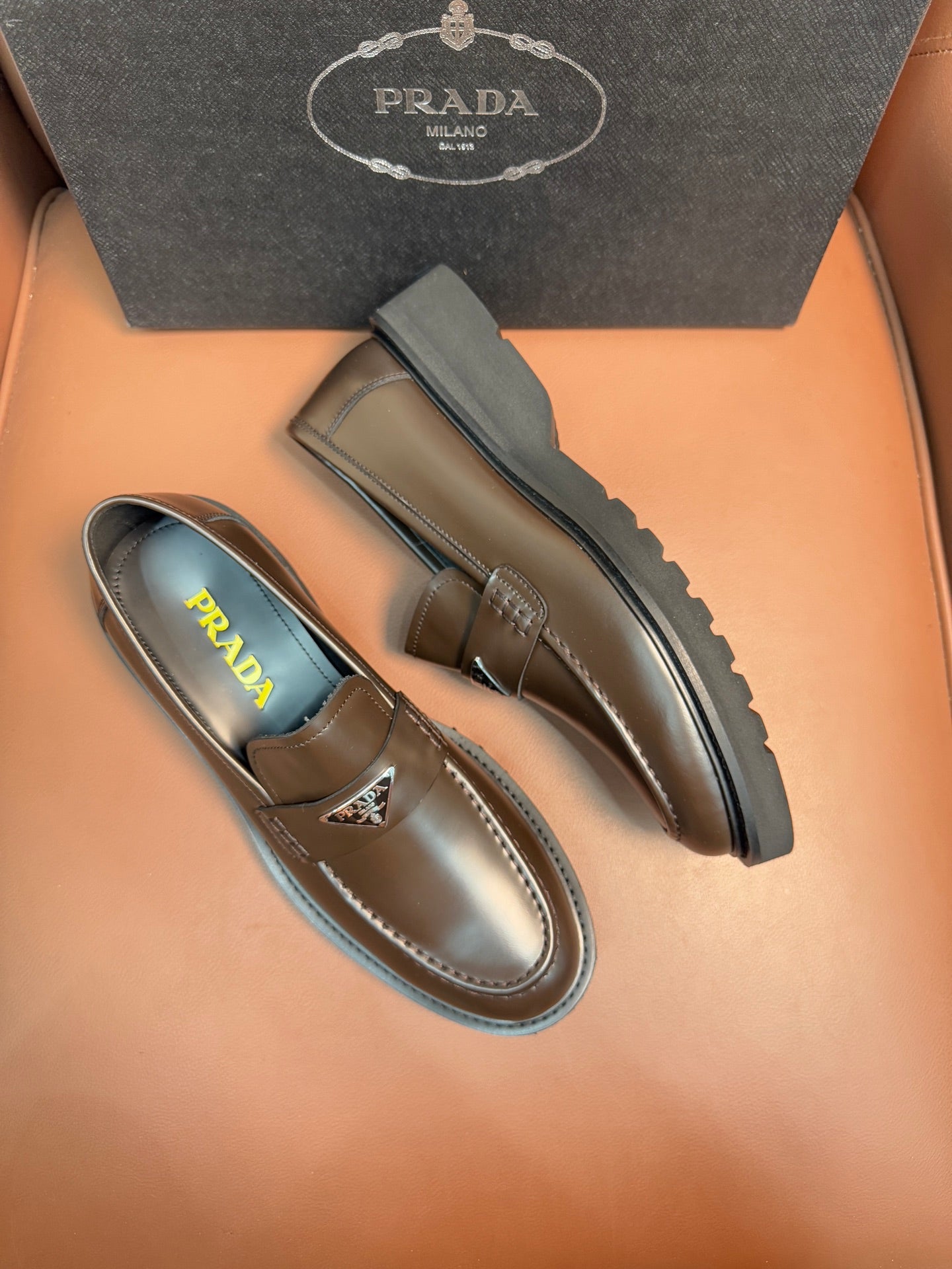 Prada unisex loafers, side view pair in dark metallic brown leather with rubber sole