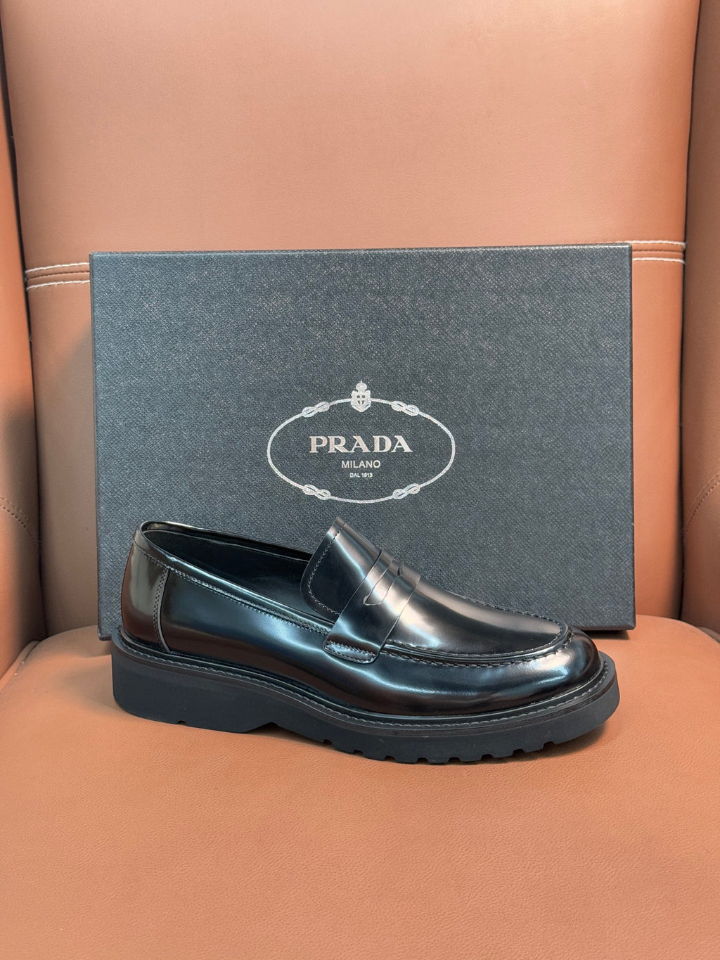 Prada unisex loafers, front view in dark metallic leather with strap and treaded sole